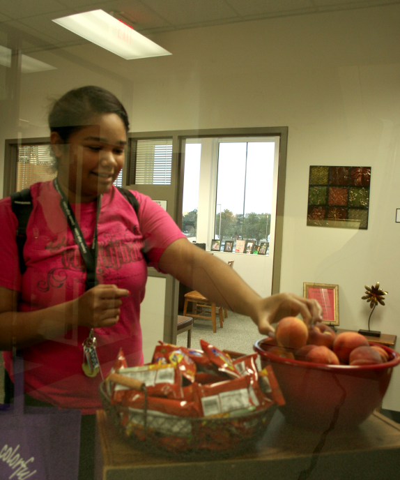 Jazlyn Palmer (9) grabs a peach from the bowl in the Associate Principals office before school starts on Friday, Oct. 7, 2011. Student Council is once again providing free fruit for students through a grant to improve healthy eating habits. Fruit will be available each day in the offices and the Media Center for anyone to take. 