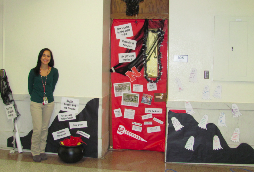 Donna Anderson poses outside of her college-decorated door, Room 105. 