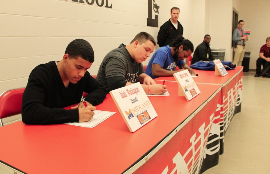 Left to Right: Isaiah Washington,  Anthony Bryan, and Kevin Franklin sign letters of intent in front of friends and family on Feb. 6, 2015 in the Athletic Conference Room at Lincoln High School. Washington and Bryan will play football at Midland University, and Franklin will play at UNK. Photo by Greg Keller