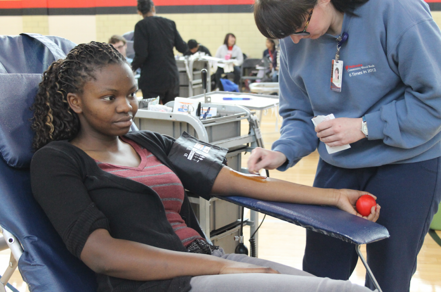 Maluba Mudundulu (12) donates blood during the StuCo/Red Cross Club Blood Drive in the West Gym on Jan. 23, 2015. Photo By Sam Stuefer