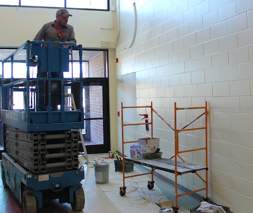 Facilities and Maintenance workers finish the repairs to  the South Gym Hall after a fire scorched the walls and melted the fire alarm. The fire was started intentionally and sent staff and students out into the cold for over 30 minutes on Jan. 30, 2015. Photo by Greg Keller