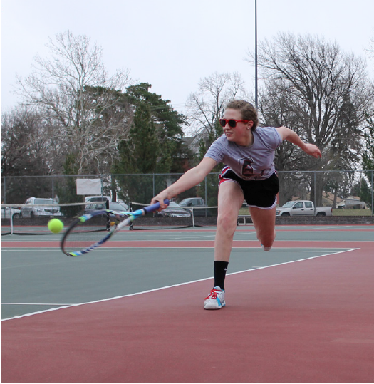 Junior Clara Higgins stretches for a tough backhand
during tennis practice. Photo by Victoria Garza