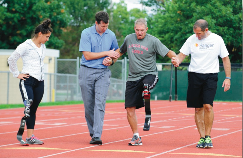 Social studies teacher Bob White tests out a running blade with support. Photo courtesy of Lincoln Journal Star.