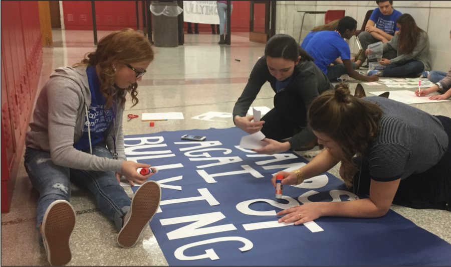 Taylor Headley (12), Mackenzie Healey (12), Kira Stahly (12), make a sign for Bands Against Bullying.
