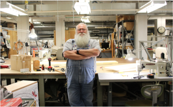 Dan Sheridan, Lincoln High’s Athletic Equipment Repairman, poses in front of his workshop desk. Photo by Ahmed Naser