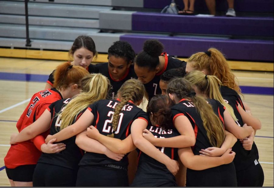 The girls on LHS’s varsity volleyball team encourage each other to work even harder during the Omaha Central game Photo Courtesy of Jaicein Mayfield (12).
