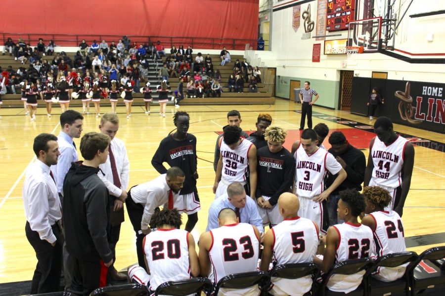 The Links Varsity Boys Basketball Team gets huddled up to plan their strategies for the rest of the game against Bellevue West on November 30, 2017 at Lincoln High. Photo by Kendy Npimnee