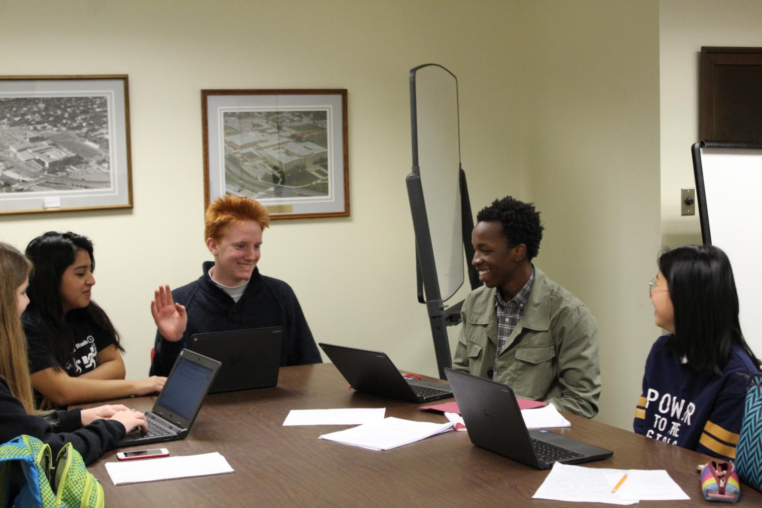 Scholars (right to left) Bailey Steinbach, Passmore Mudundulu, Alba Argueta, and Peyton Erickson prepare for their International Baccalaureate psychology final with the assistance of Cooper Hicks (center) in the Media Center during 4th period. The Media Center tends to get busier as finals approach. Photo by Sara Balter