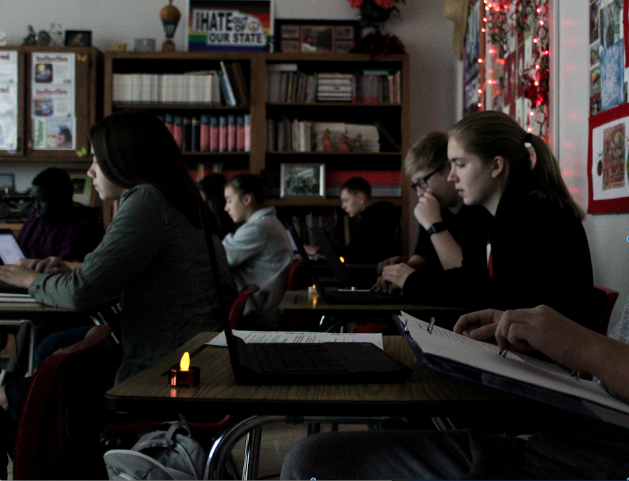  Lydia Skold (left), Jack Amen (right back ) and Olivia Haller (right front) write by candlelight in Deborah McGinns 9th grade Pre-IB English class. Photo by Maicee Ingwerson