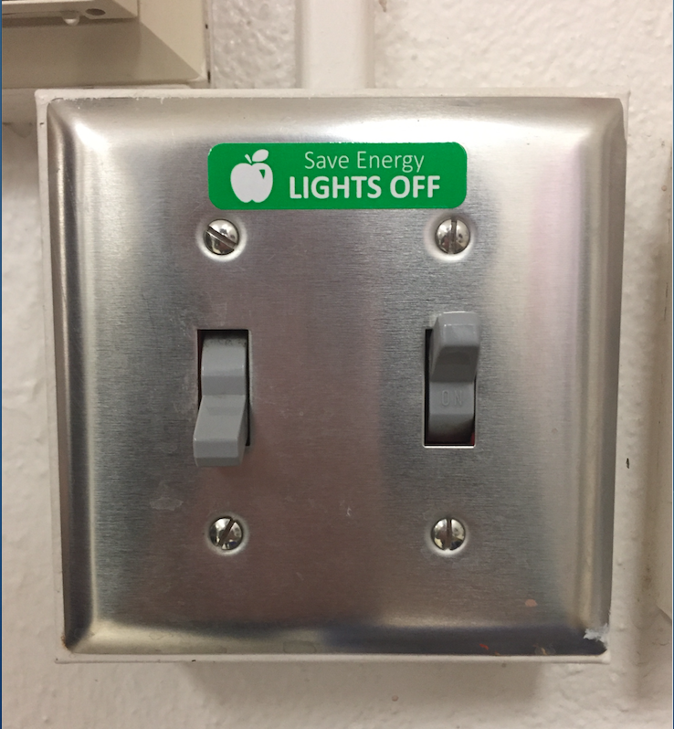 The art rooms light switch displays a Save Energy LIGHTS OFF sticker, among many other switches in the building. Photo by Rukhshona Islamova. 