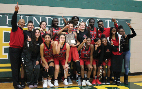 The 2018 District Champion Varsity Girls Basketball Team: (Front Row) - Nikta Shariati, Maya Thomas (22), Chely Herrera (40), DonTaysha Luter (00), Journee Martin, Franzanae Wynn (Back Row standing) - Coach Richard Jackson, Shasa Bussard, NaTayah Wilson, Nyayien Koang, Briley Phillip (holding District Championship plaque), Nyagoa Gony, Ashton Rutsay, Nyayongah Gony, Coach Flowers, Coach Overstreet, Akmundria Roberts. Photo by Samuel Joseph