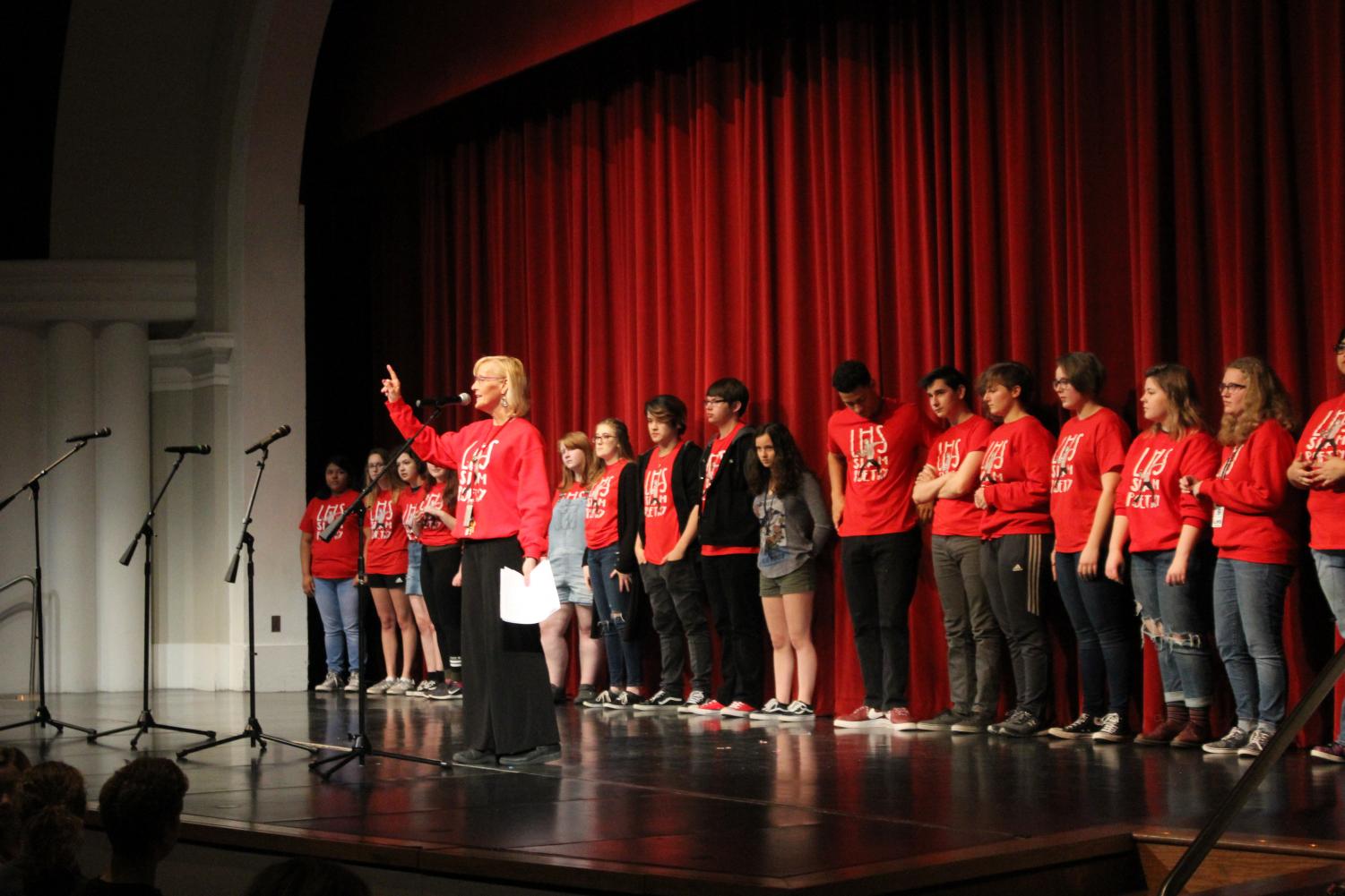 The Lincoln High Slam Poetry Team stands on the Ted Sorensen Theatre stage during a send-off for the team’s state bout for the Louder Than a Bomb Great Plains poetry competition at the Holland Center in Omaha on April 24, 2018. The team won first place. Photo by Gillian Kohl