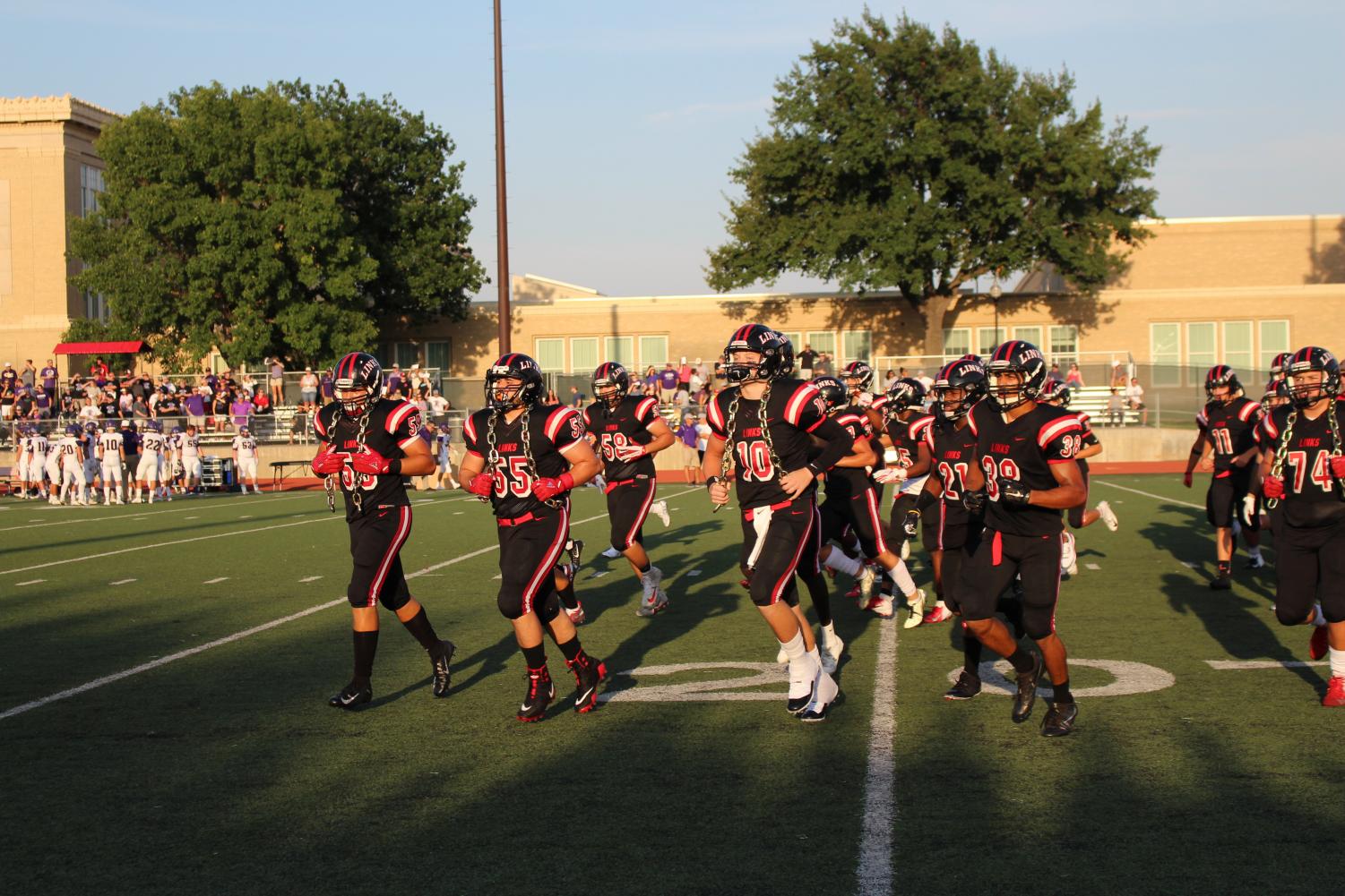 Lincoln High Varsity football players run out onto the field before the Grand Island game begins on August 31st at LHS. Photo by Emily Price.