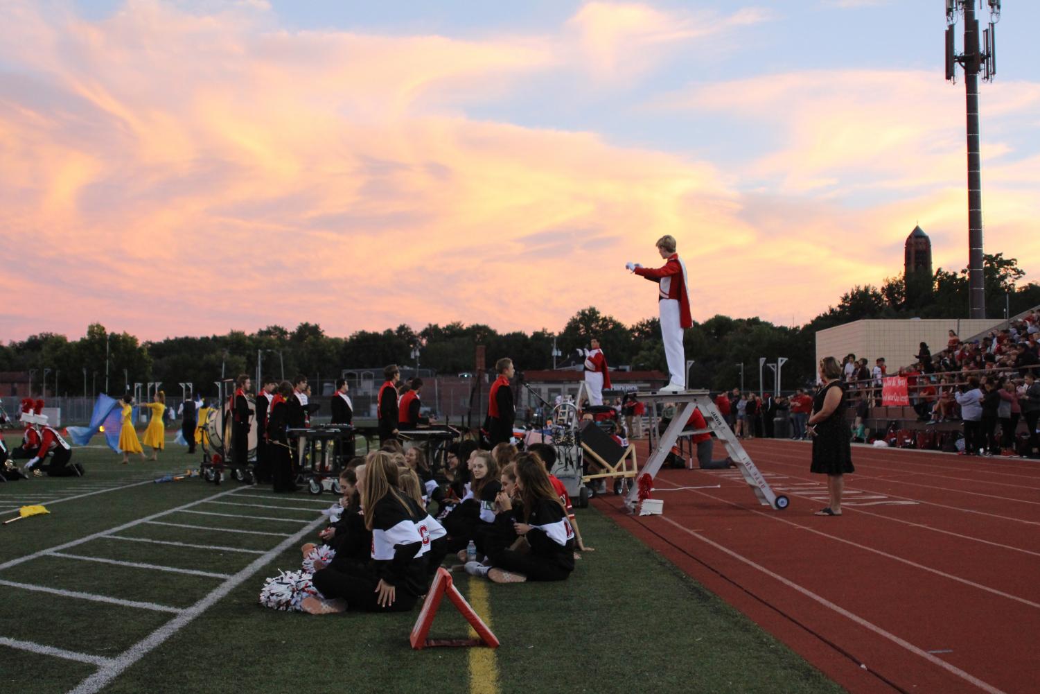The sky provides a dramatic backdrop as Drum Major Luke Moberly (11) leads the LHS Marching Band in a song at the Homecoming football game on Friday, Sept. 21, 2018 at Beechner Athletic Complex. Saxophone player Jacob Vanderford (11) sings a solo during the performance. The Links defeated Omaha Central 49-6. Photo by Anthony Torres
