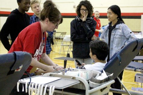 Nebraska Community Blood Bank Nurse Holly Feese helps Bryant Pedreza (12) donate blood during the Red Cross Club Blood Drive in the West Gym on Friday, Oct. 5, 2018 while Will Brandt (12), Passmore Mudundulu (12), Zane Morales (10), and Cecelia Nguyen (10) provide moral support. Photo by Meg Boedeker