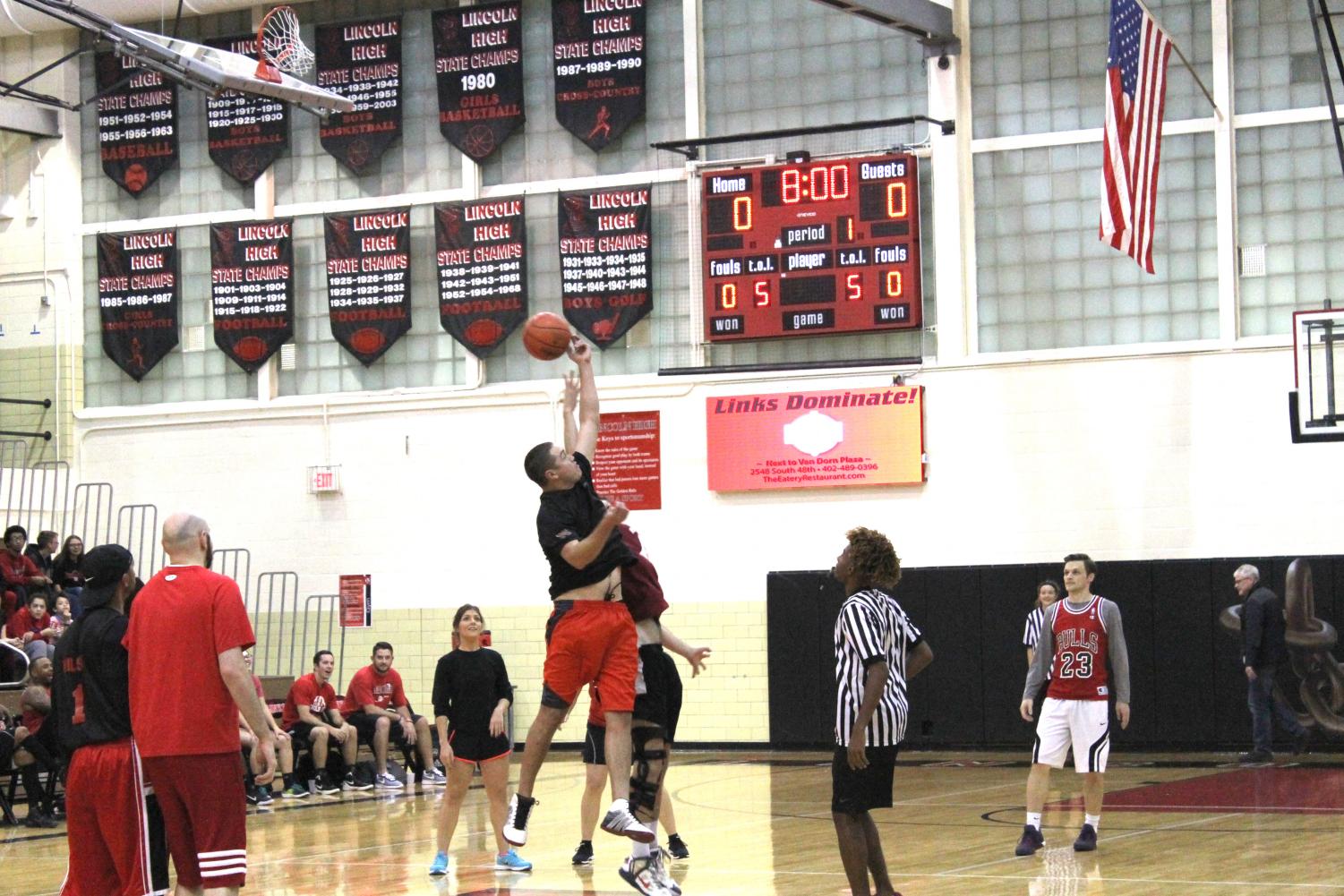 Faculty members start the 2018 Hoops for Hope game with a jump. Students officiated and coached the teams. Photo by Dat Nguyen.