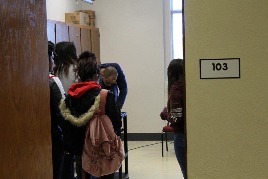 Attendance Interventionist Montsho Wilson writes tardy passes for students on January 9th, 2019 in Room 103. This was the first day this policy went into effect. Photo by Zeke Williams