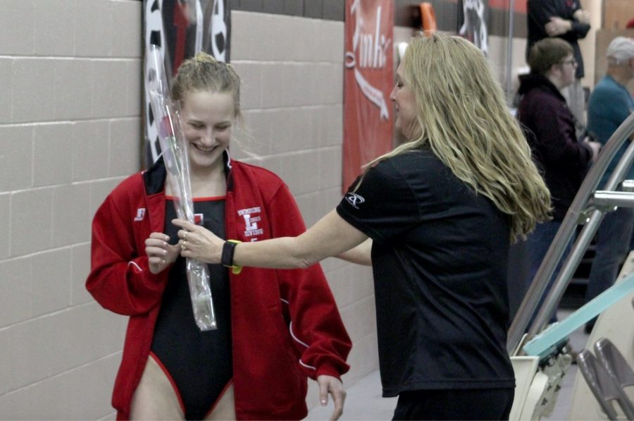 Senior Colleen Arnold receives a rose from Assistant Coach Sharill Luedtke on Senior Night at the Swimming and Diving meet at LHS on Jan. 29, 2019. Photo by Zeke Williams