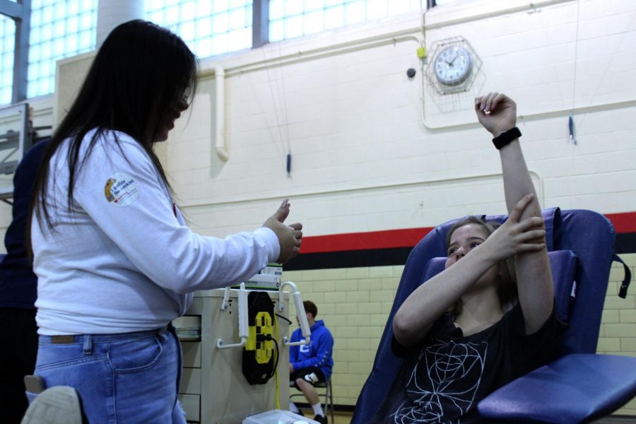 Samantha Duffy (11) donates blood while Holly Hoang (11) helps the staff with the process at the Fourth Quarter blood drive on May 3rd, 2019. This was the last blood drive of the year. Photo by Zeke Williams