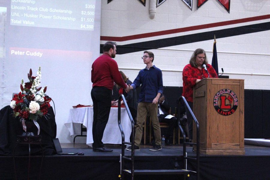 Student Council President Eric Lesiak (12) accepts an award from Music Department Chair Brett Noser at the Senior Honors Assembly on May 13th, 2019. Photo by Linh Ngo