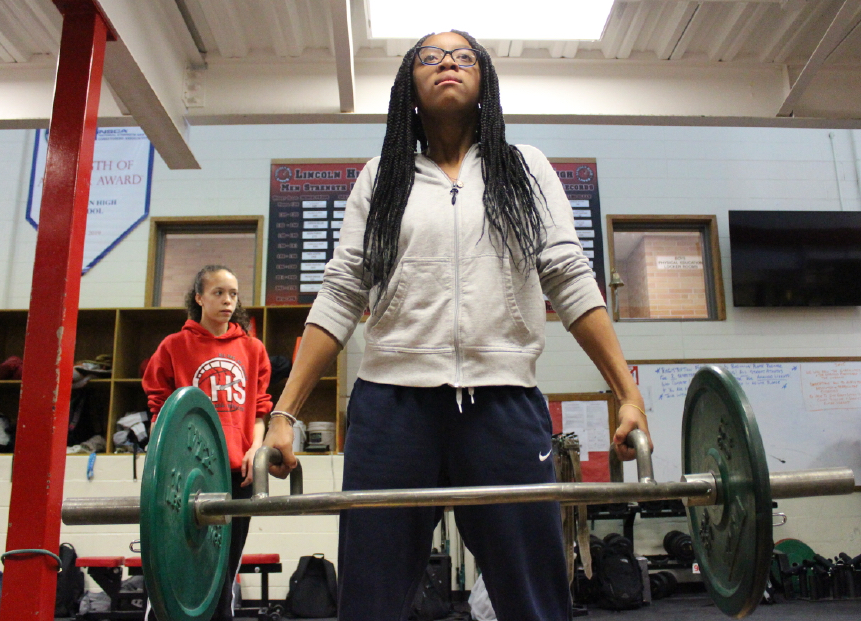 Serenity Williams (9) does Hex bar shoulder shrugs in Mark Mackes 6th period weight training class. Photo by Brittyn Schutz
