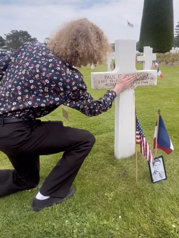 Kieran Wagner (11) rubs dirt brought from Lincoln High School into the burial marker at the Normandy American Cemetery at the 80th anniversary of D-Day on Thursday.