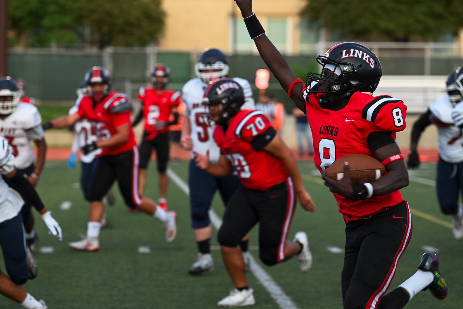 LHS senior, Pal Jock, races the football being blocked by junior Doh Doh during the game on Friday against the Huskies. The Links went on to score 50 points during the game, shutting out the Huskies.