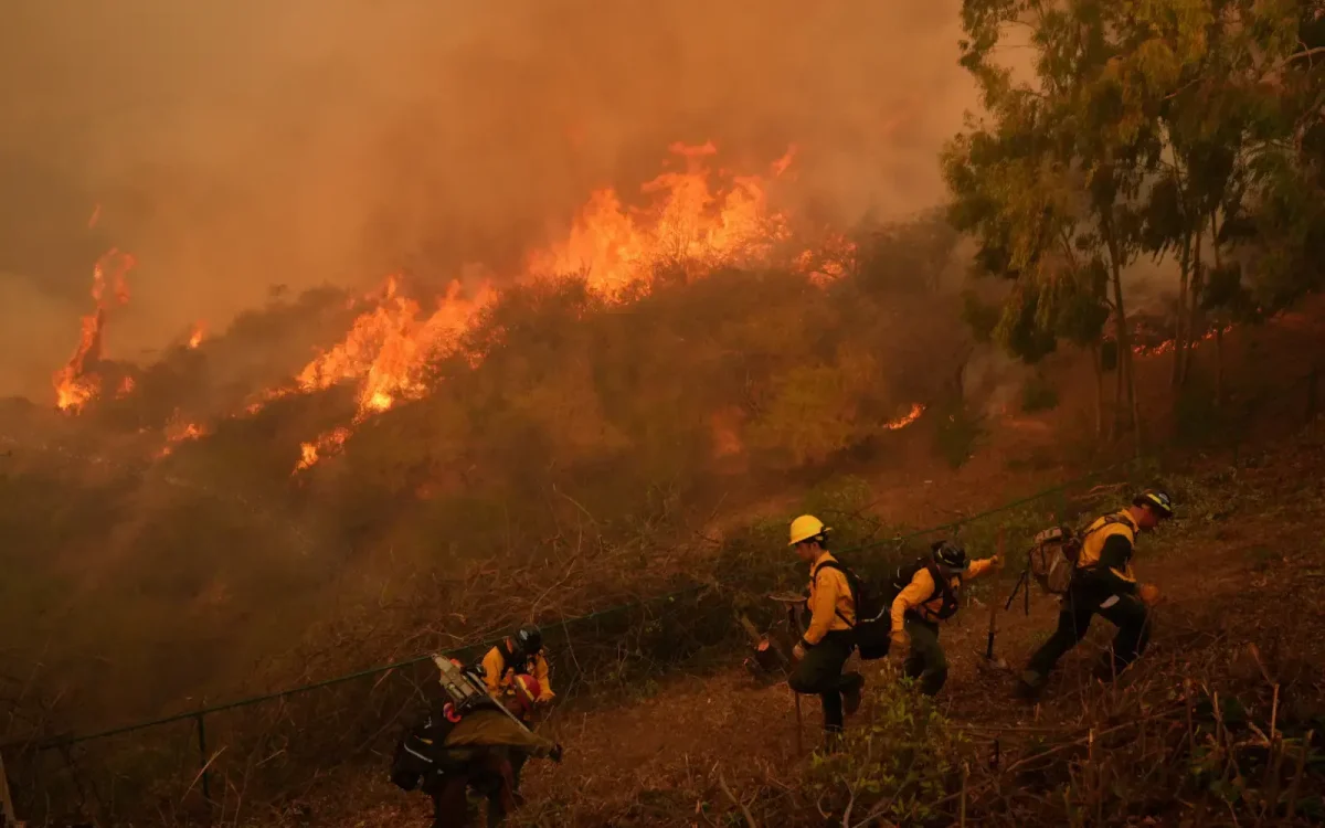 The still-spreading flames threaten communities in the populous San Fernando Valley on Sunday. (AP)