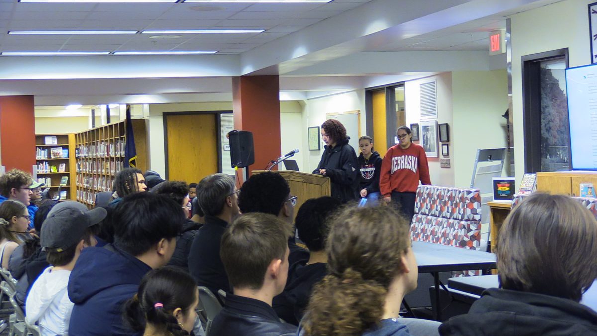 Student from audience reading poetry aloud.